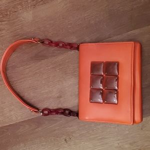 Papaya colored clutch with Acrylic chain trim